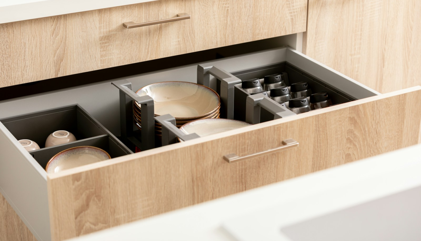 an open drawer in a kitchen filled with dishes