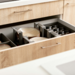 an open drawer in a kitchen filled with dishes