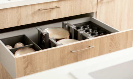 an open drawer in a kitchen filled with dishes