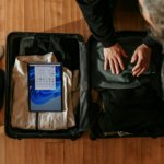 an overhead view of a person packing a suitcase