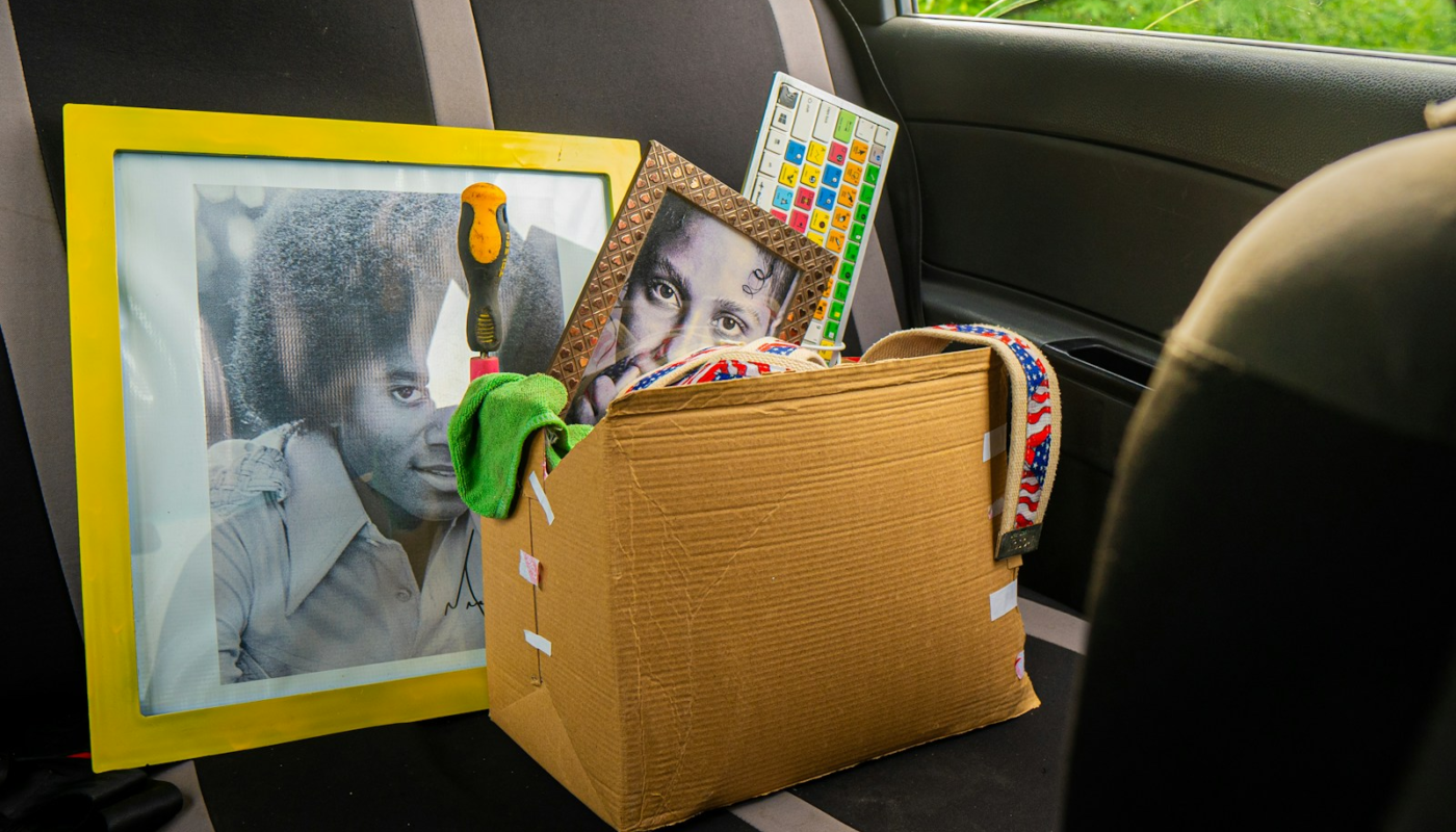 Box of items and framed pictures in car backseat