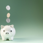 Coins falling into a white piggy bank.