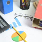 Desk with calculator, charts, and binders