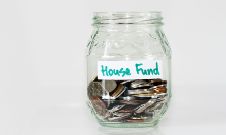 coins in clear glass jar with house fund sign