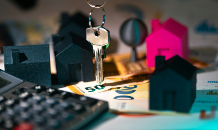 A calculator, keychain, and house model on a table