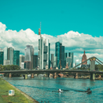bridge over river near city buildings during daytime
