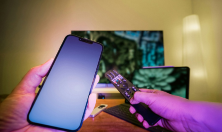 A person holding a cell phone and a remote control