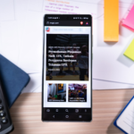 Smartphone on desk with calculator and sticky notes.