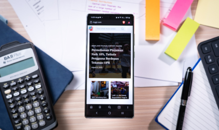 Smartphone on desk with calculator and sticky notes.
