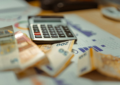 A calculator sitting on top of a pile of money