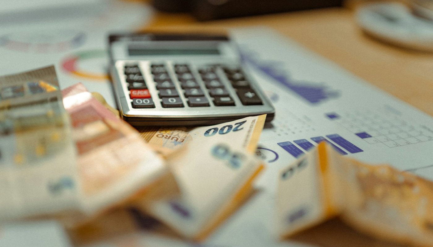A calculator sitting on top of a pile of money