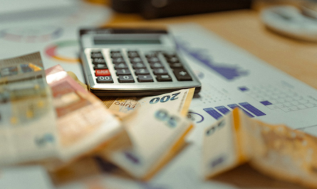 A calculator sitting on top of a pile of money