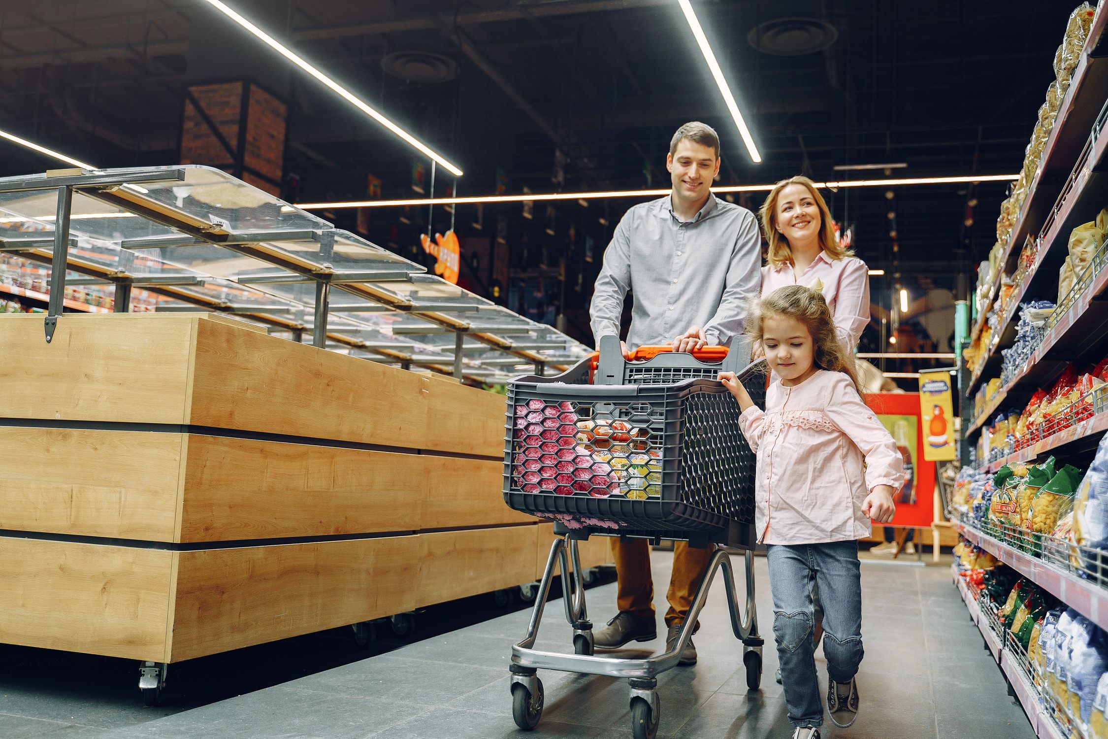 Family comparing grocery prices while shopping in a supermarket
