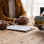 Mortgage closing documents, calculator and house keys for comparing closing costs