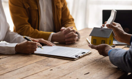 Mortgage closing documents, calculator and house keys for comparing closing costs