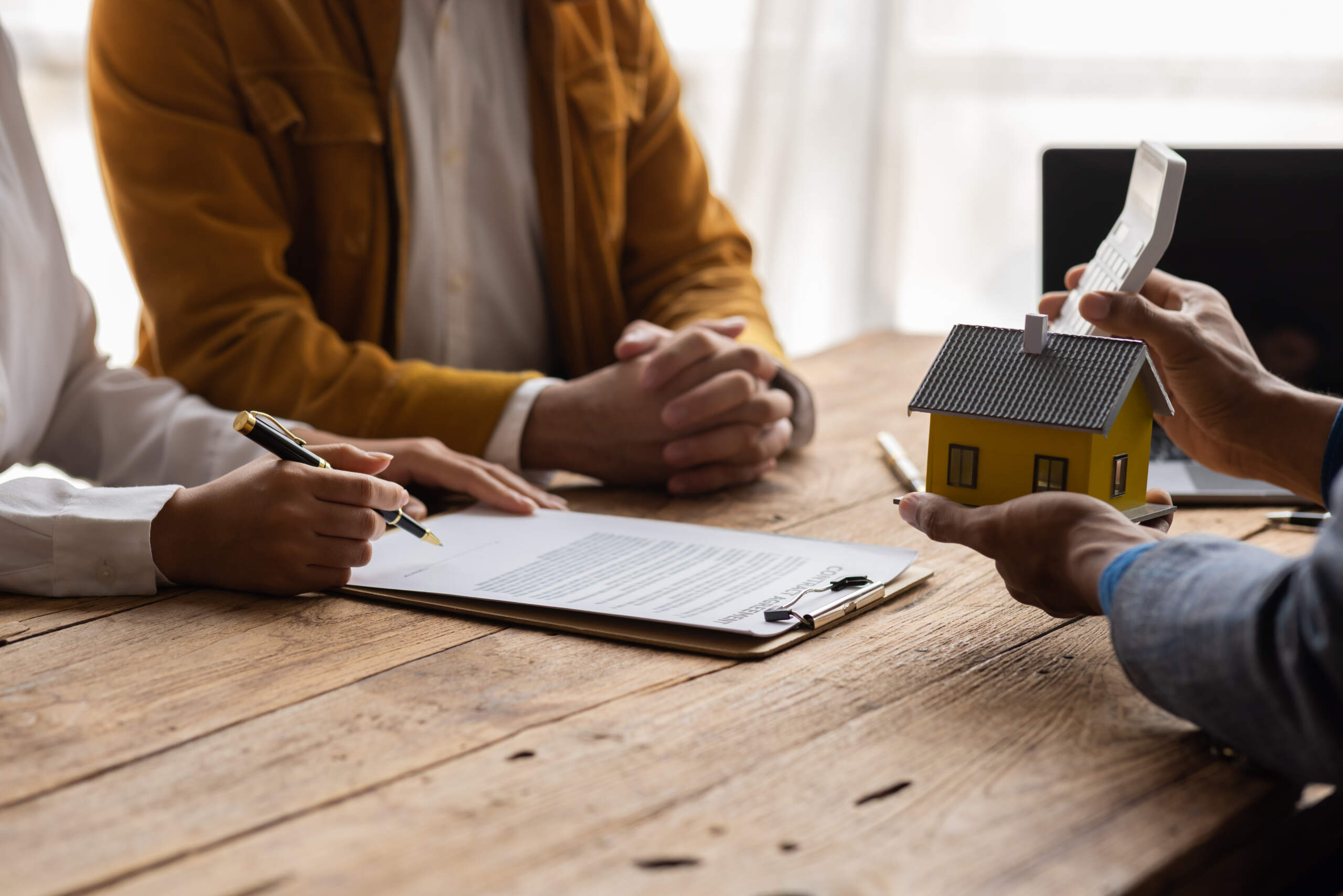 Mortgage closing documents, calculator and house keys for comparing closing costs